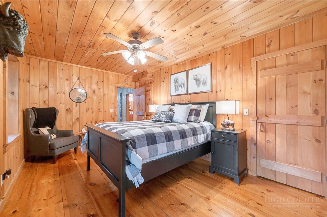 376 Yellow Bear Road Todd, NC 28684 - Photo 28 of 29 a bedroom with a bed and a chandelier