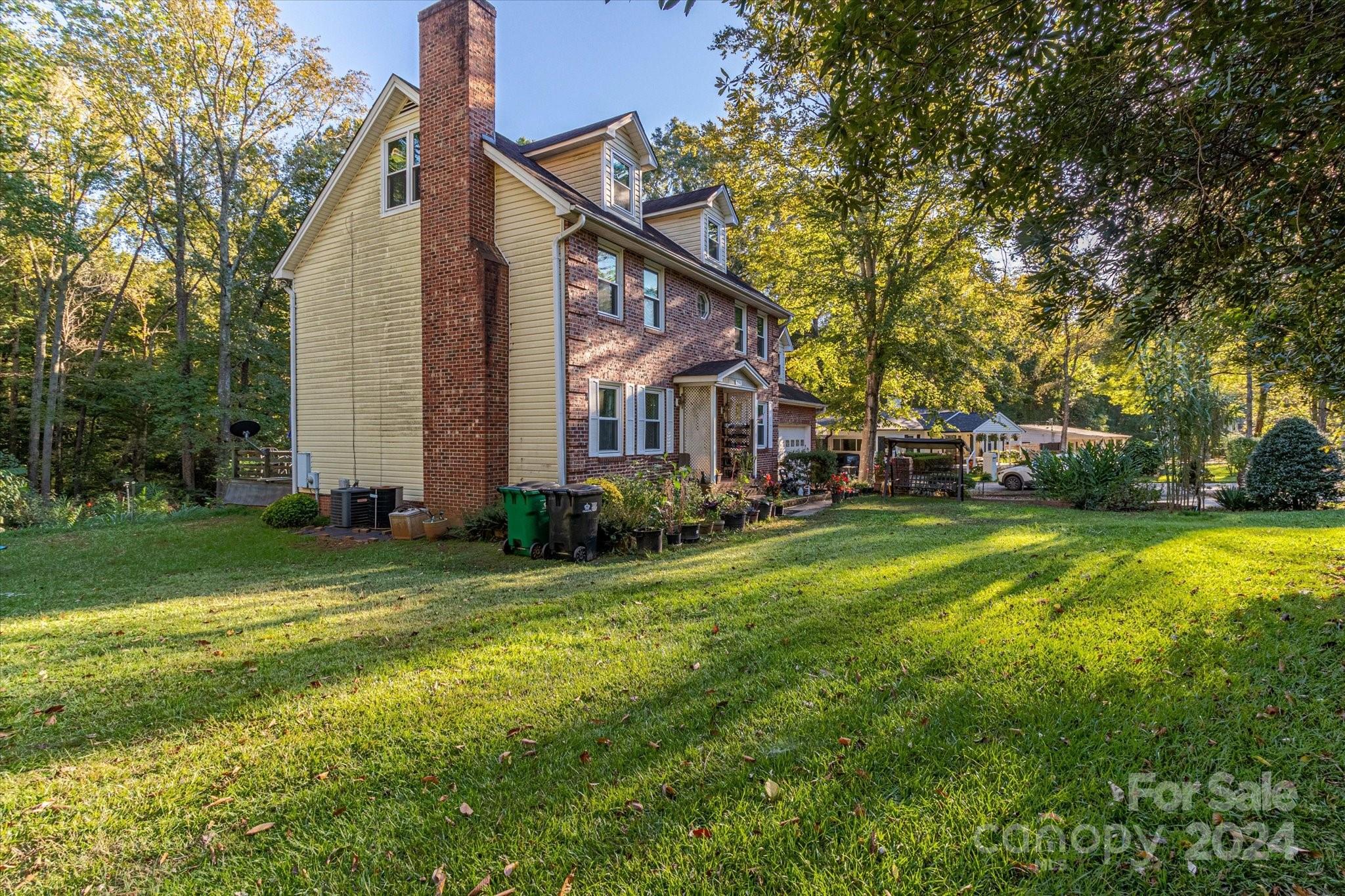 2131 Pinebrook Circle Charlotte, NC 28208 - Photo 4 of 23 a view of a house next to a big yard and large trees
