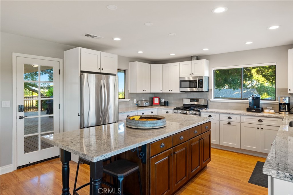 115 Booker Road Templeton, CA 93465 - Photo 39 of 76 a kitchen with stainless steel appliances granite countertop a refrigerator a sink dishwasher a stove and white cabinets with wooden floor