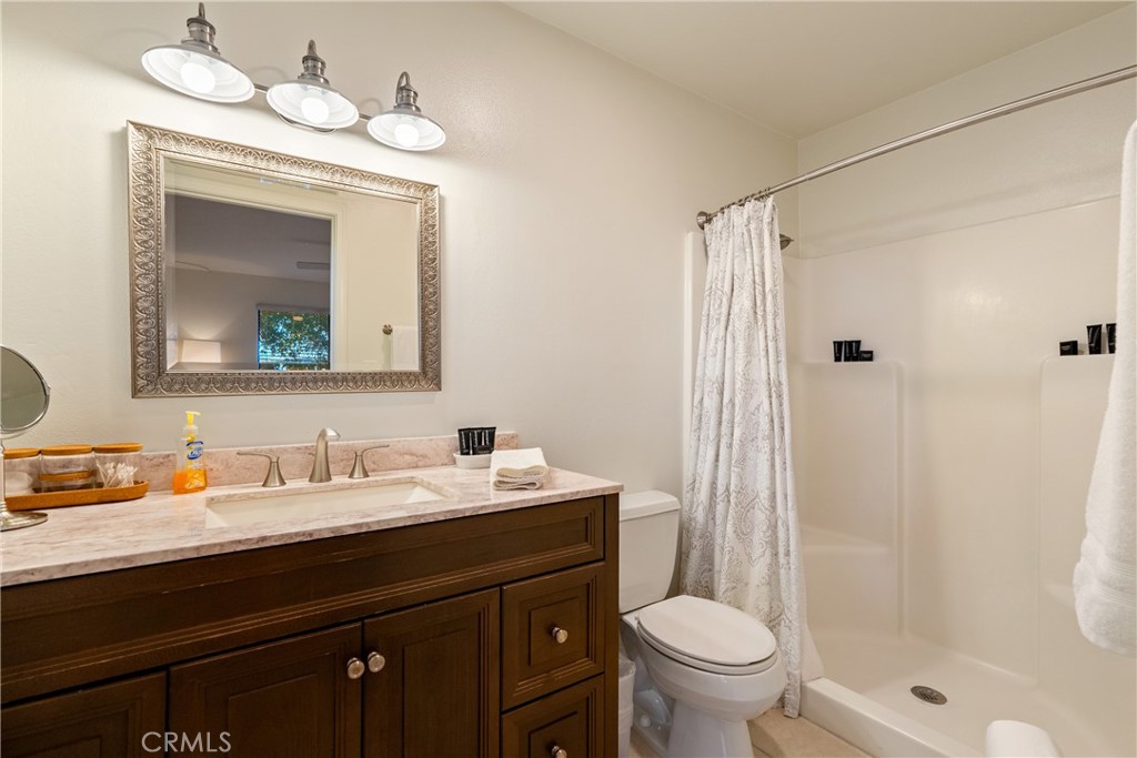 115 Booker Road Templeton, CA 93465 - Photo 47 of 76 a bathroom with a toilet a sink a mirror a vanity and shower