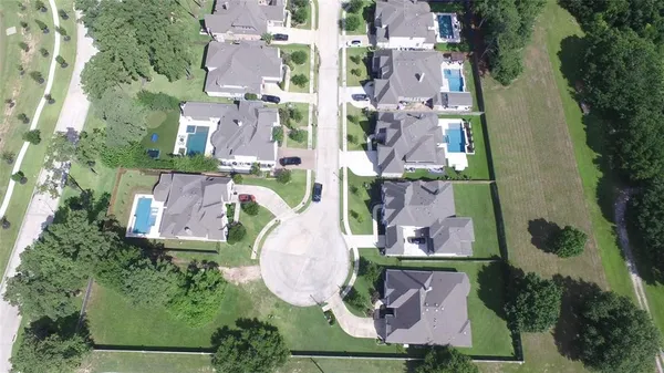 an aerial view of residential houses with outdoor space and parking