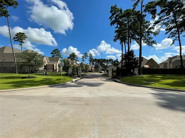 a view of a house with a big yard and large trees