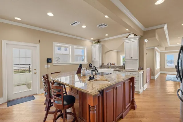 a dining room with wooden floor a chandelier a wooden table and chairs