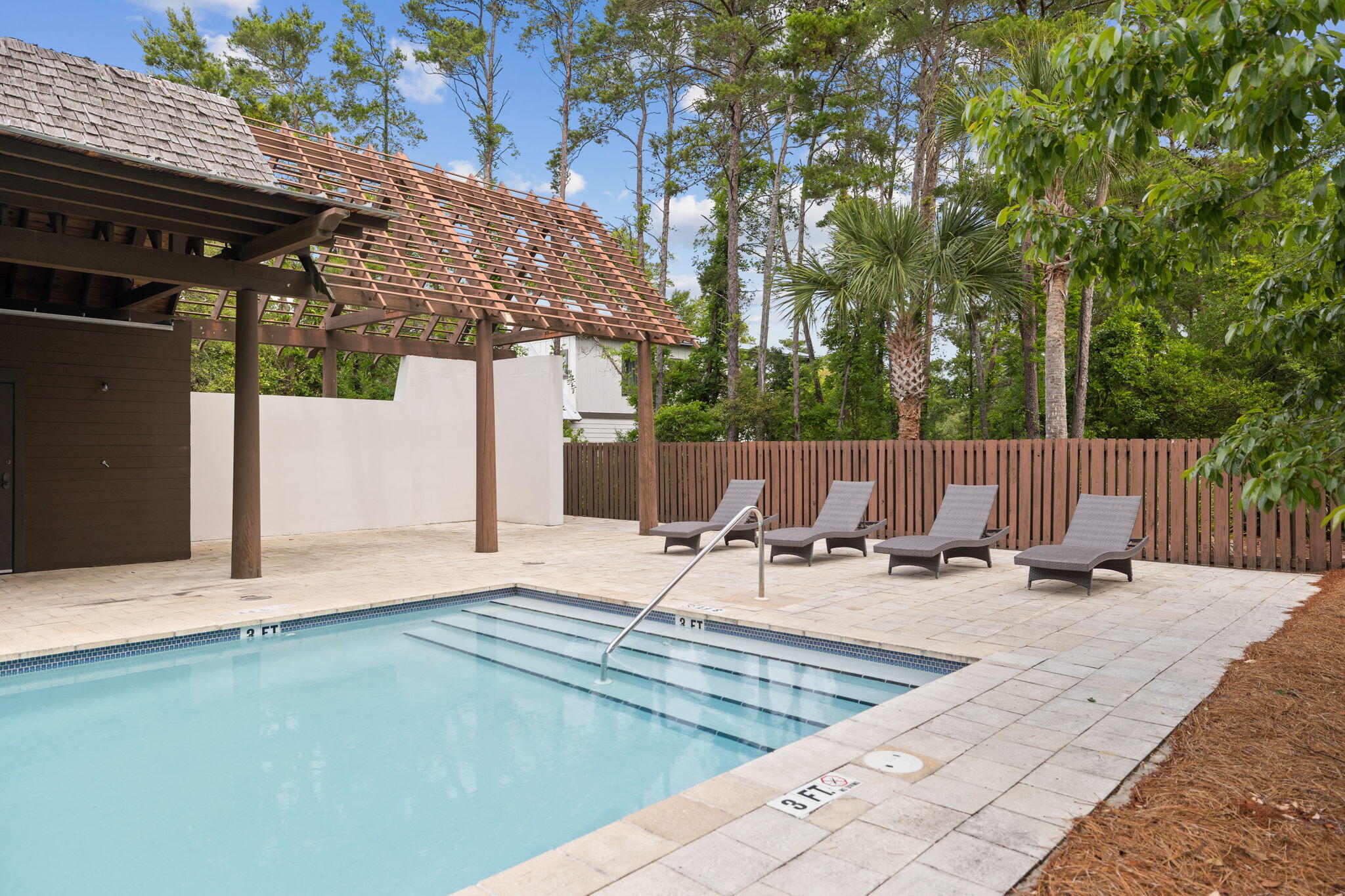 107 Pine Cone Inlet Beach Inlet Beach, FL 32461 - Photo 22 of 24 a view of pool with lawn chairs and wooden fence