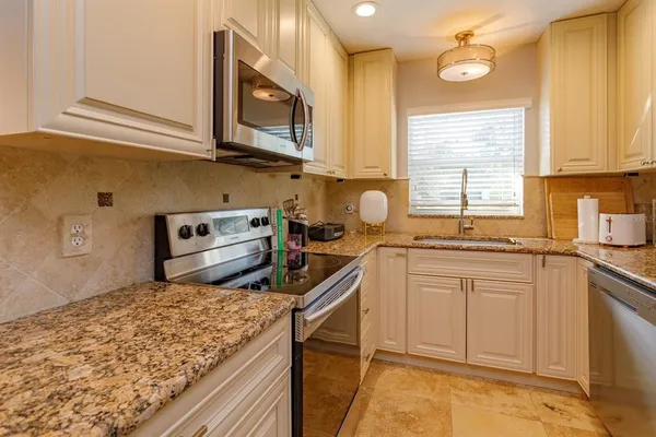 a kitchen with stainless steel appliances granite countertop a sink stove and cabinets