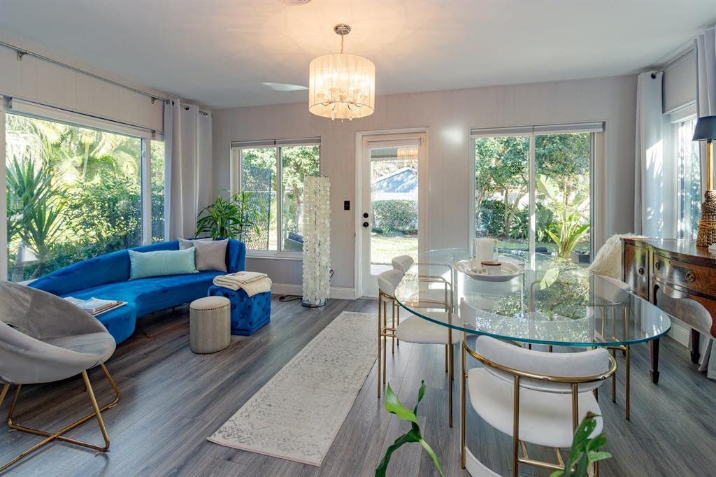 1105 Strathmore Drive Orlando, FL 32806 - Photo 14 of 25 a dining room with wooden floor a chandelier a glass table and chairs