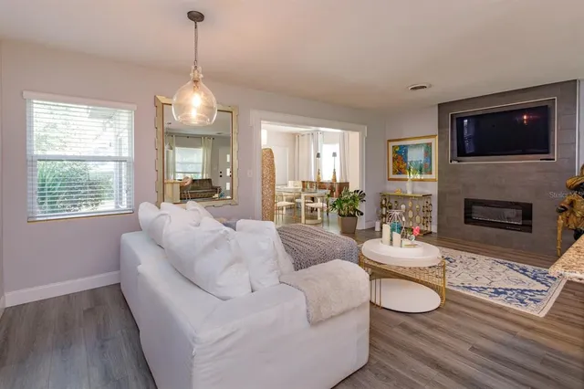 a living room with furniture a flat screen tv and a fireplace