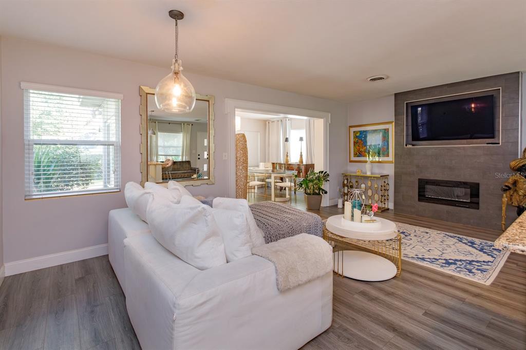 1105 Strathmore Drive Orlando, FL 32806 - Photo 5 of 25 a living room with furniture a flat screen tv and a fireplace