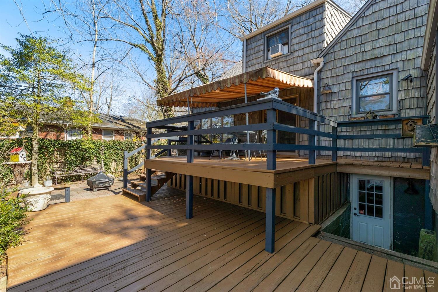 424 Chain O' Hills Road Colonia, NJ 07067 - Photo 11 of 36 a view of a roof deck with table and chairs under an umbrella with wooden floor