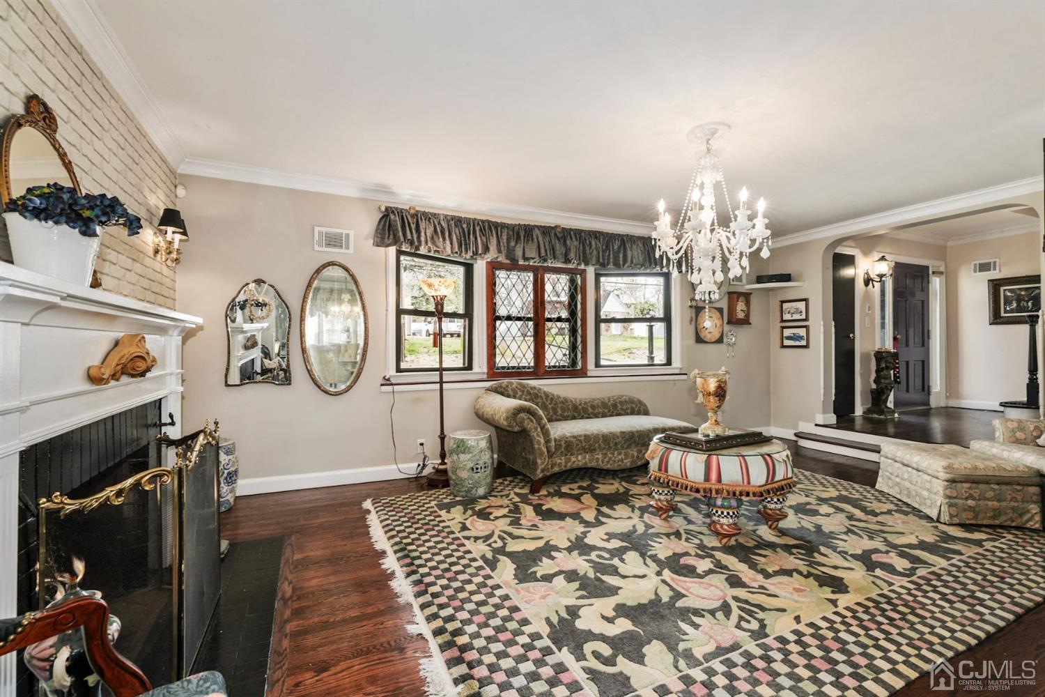 424 Chain O' Hills Road Colonia, NJ 07067 - Photo 24 of 36 a living room with furniture a fireplace and a chandelier