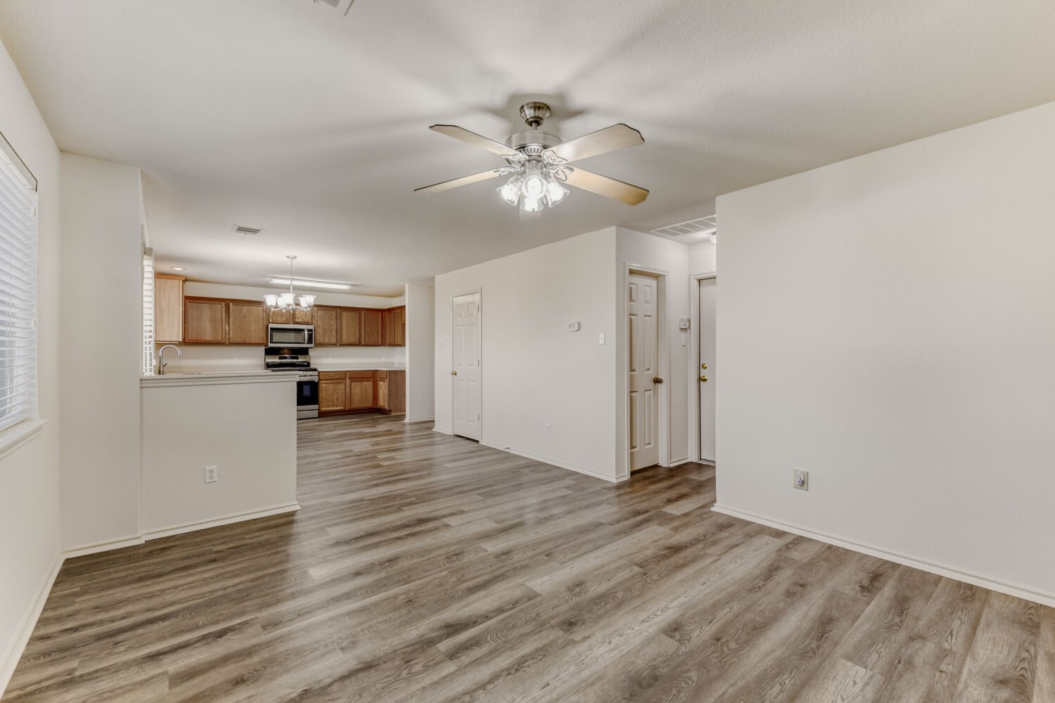 14716 Lipton Lane Pflugerville, TX 78660 - Photo 5 of 26 a view of a kitchen with wooden floor and a ceiling fan