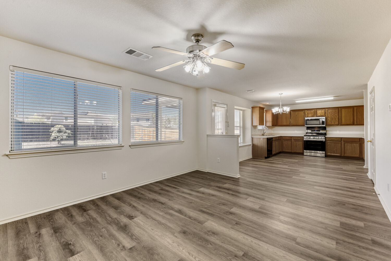 14716 Lipton Lane Pflugerville, TX 78660 - Photo 6 of 26 a view of an empty room with a window and wooden floor