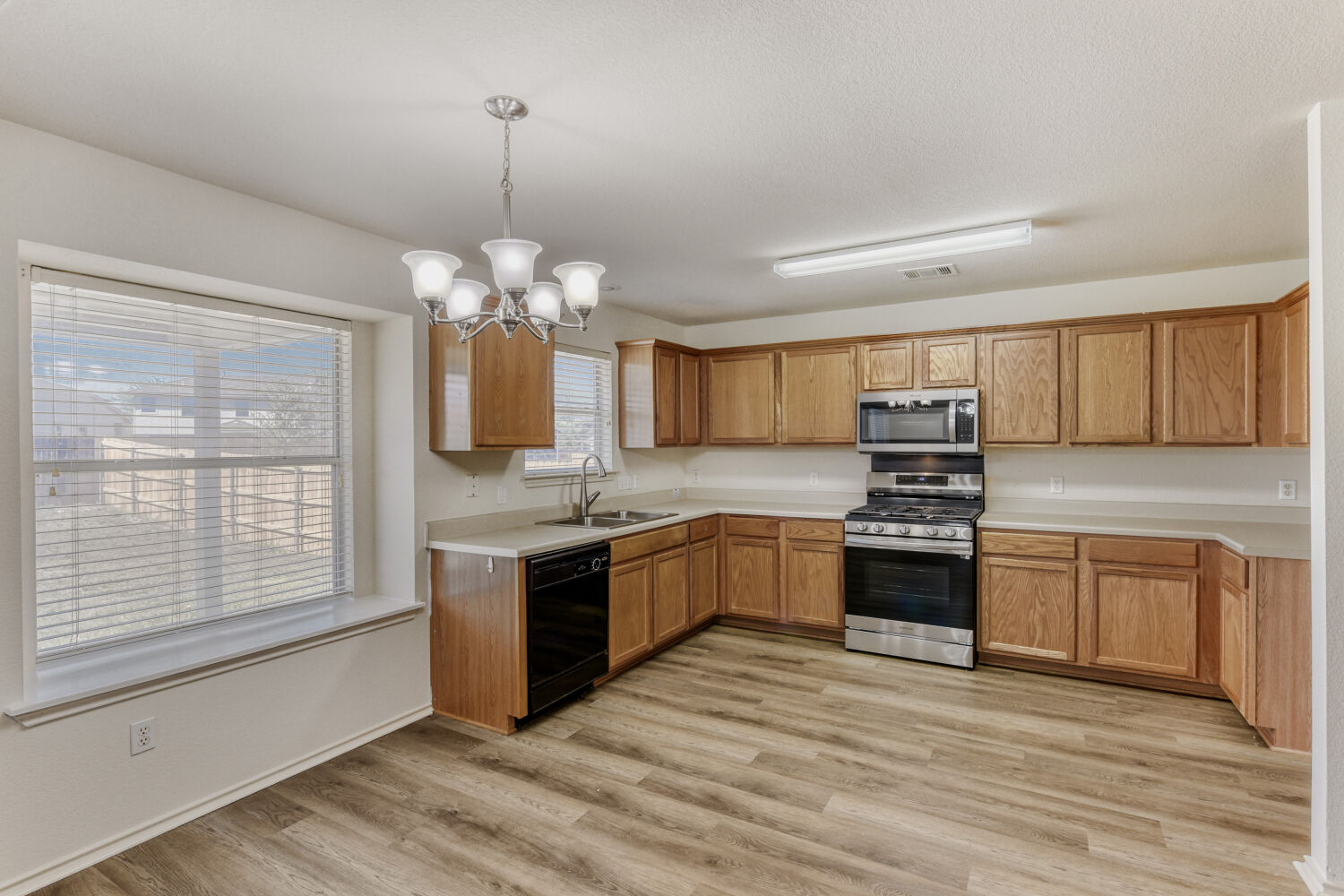 14716 Lipton Lane Pflugerville, TX 78660 - Photo 7 of 26 a large kitchen with granite countertop a stove and a sink
