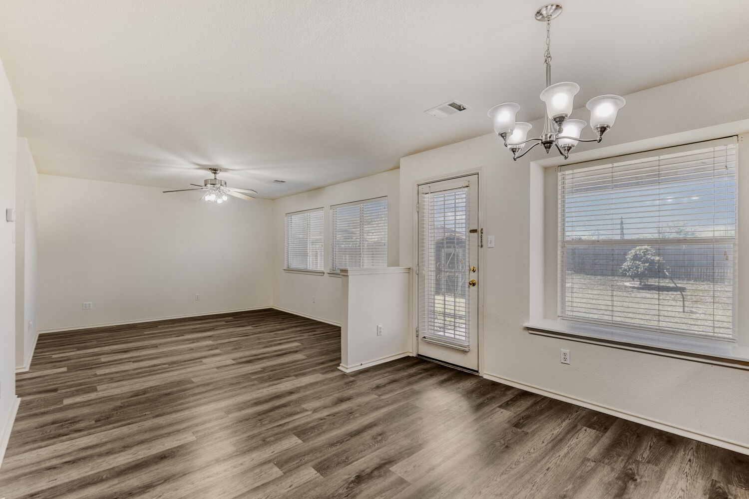 14716 Lipton Lane Pflugerville, TX 78660 - Photo 8 of 26 a view of an empty room with a window and wooden floor