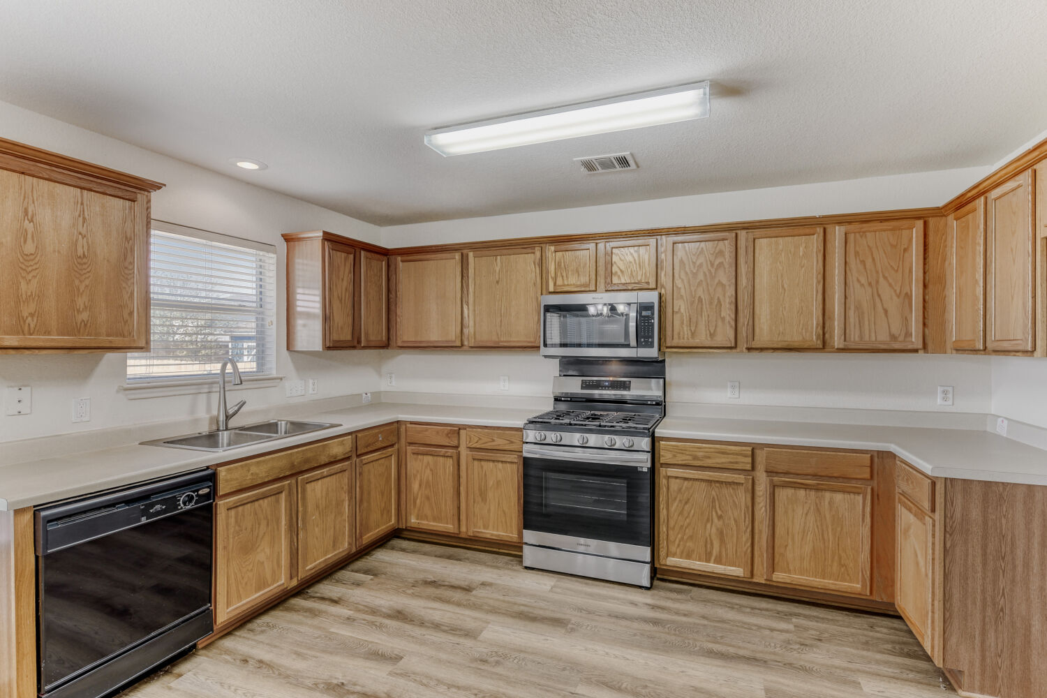 14716 Lipton Lane Pflugerville, TX 78660 - Photo 9 of 26 a kitchen with stainless steel appliances granite countertop a sink stove and cabinets