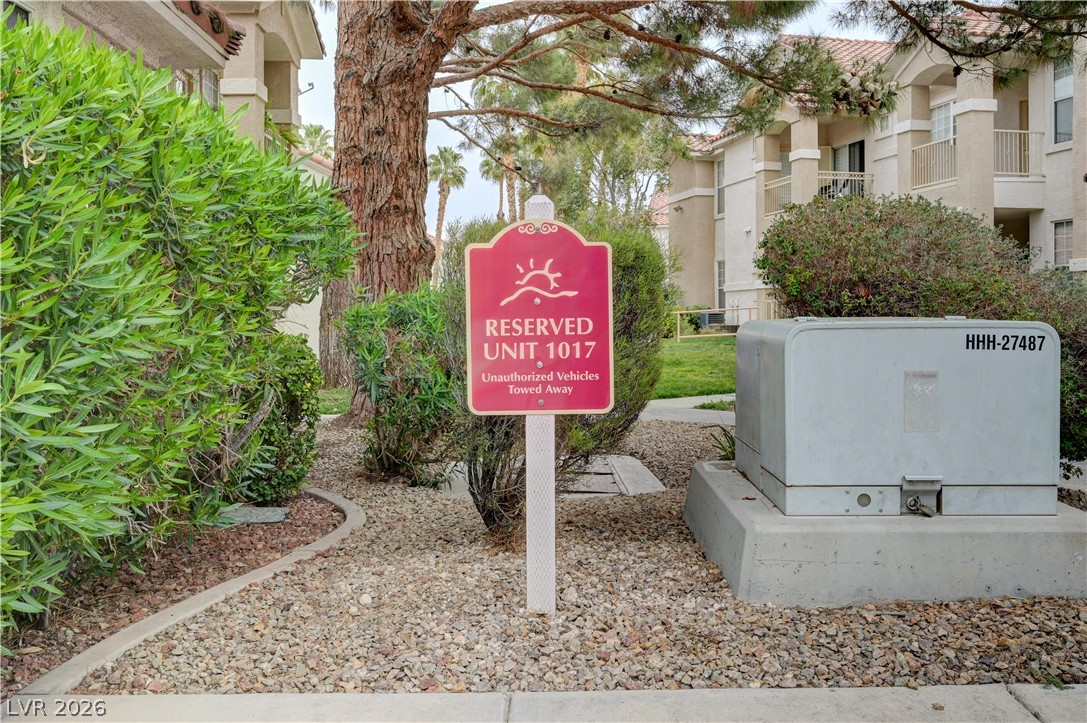 8555 West Russell Road, Unit 1017 Las Vegas, NV 89113 - Photo 23 of 34 Mature trees and vibrant shrubbery frame the entrance to a well-maintained multi-unit property.