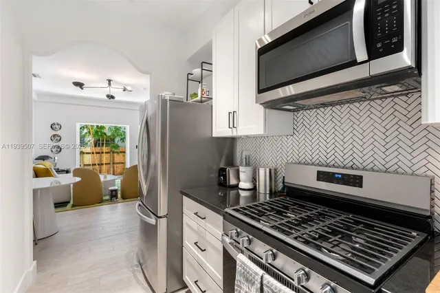 a kitchen with stainless steel appliances a stove a microwave a sink and cabinets