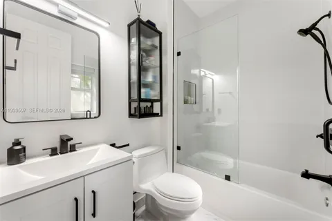 a bathroom with a sink toilet vanity and shower