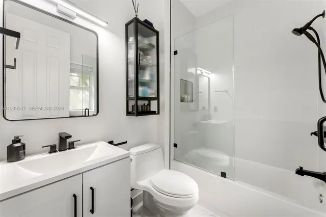 a bathroom with a sink toilet vanity and shower