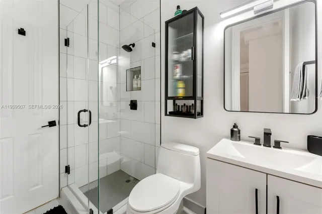 a bathroom with a toilet sink vanity and shower