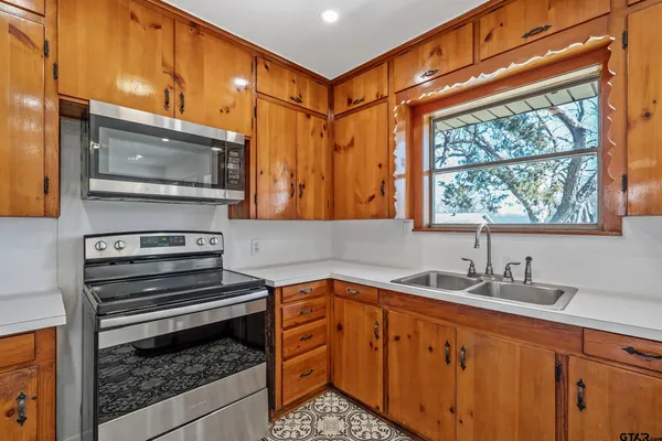 a kitchen with stainless steel appliances kitchen island granite countertop a sink and cabinets