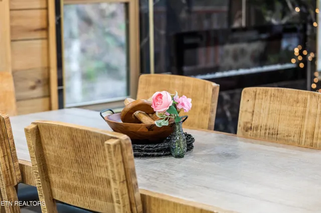 a kitchen with stainless steel appliances a table chairs refrigerator and microwave