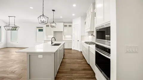 a kitchen with stainless steel appliances kitchen island granite countertop a sink and a refrigerator