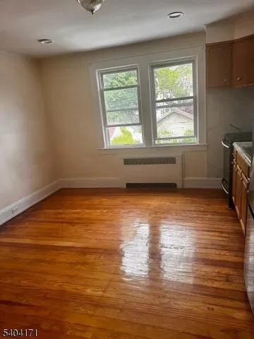 a view of room with window and wooden floor