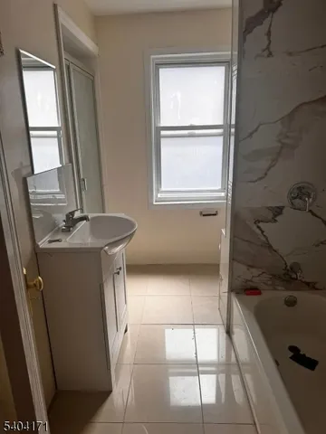 a bathroom with a bathtub sink and mirror