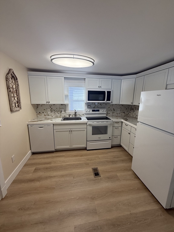 a kitchen with white cabinets and white appliances