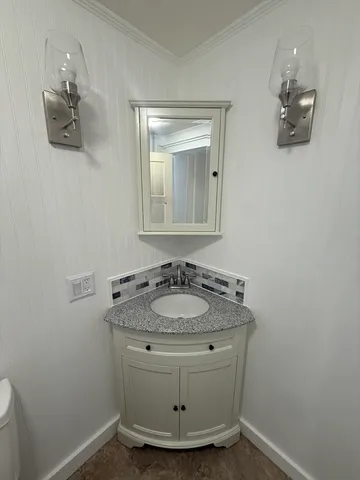 a bathroom with a granite countertop sink a mirror and vanity