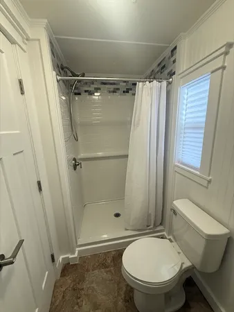 a bathroom with a toilet and a shower