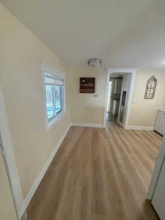 a view of a bedroom with wooden floor and a window