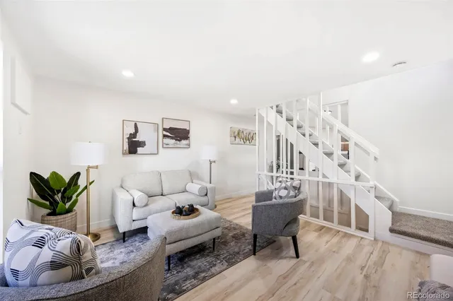 a living room with furniture and a wooden floor