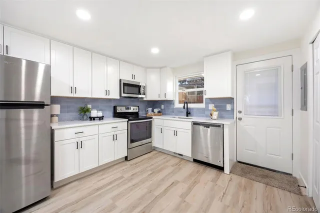 a kitchen with a refrigerator and a stove top oven
