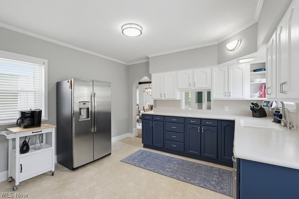 23055 Snell Road Columbia Station, OH 44028 - Photo 13 of 50 Kitchen featuring two-tone cabinetry with white upper and blue lower cabinets, light-toned countertops, a stainless steel side-by-side refrigerator, and a built-in sink
