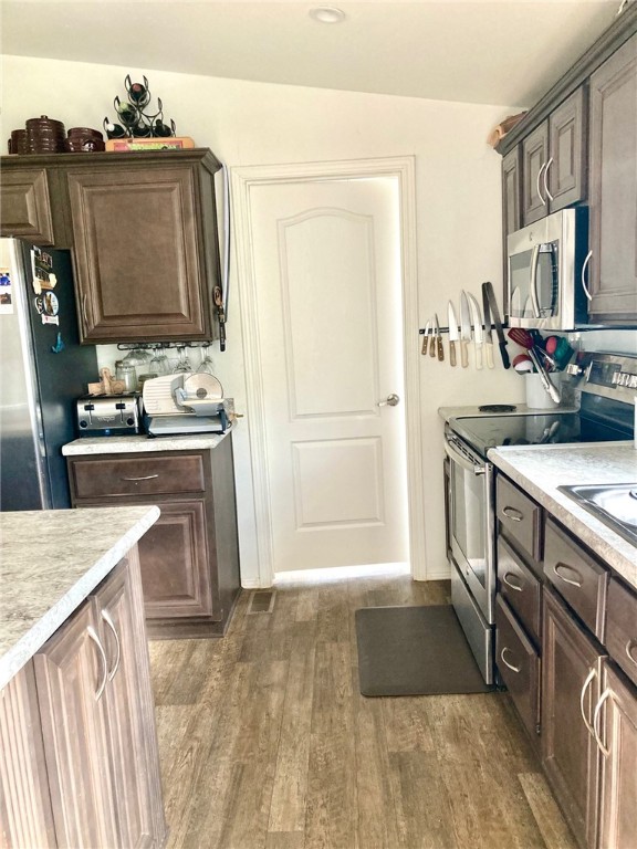 9918 East Blake Ranch Road Kingman, AZ 86401 - Photo 12 of 26 Kitchen with stainless steel appliances, wood finished floors, and dark wood finish cabinets