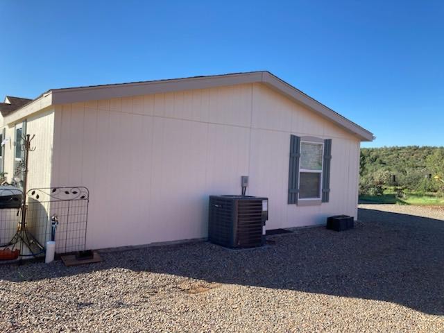 9918 East Blake Ranch Road Kingman, AZ 86401 - Photo 20 of 26 View of property exterior featuring a central air condition unit