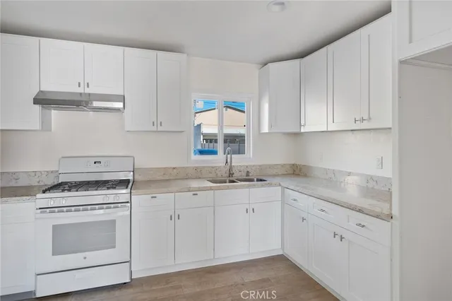 a kitchen with granite countertop white cabinets and white appliances