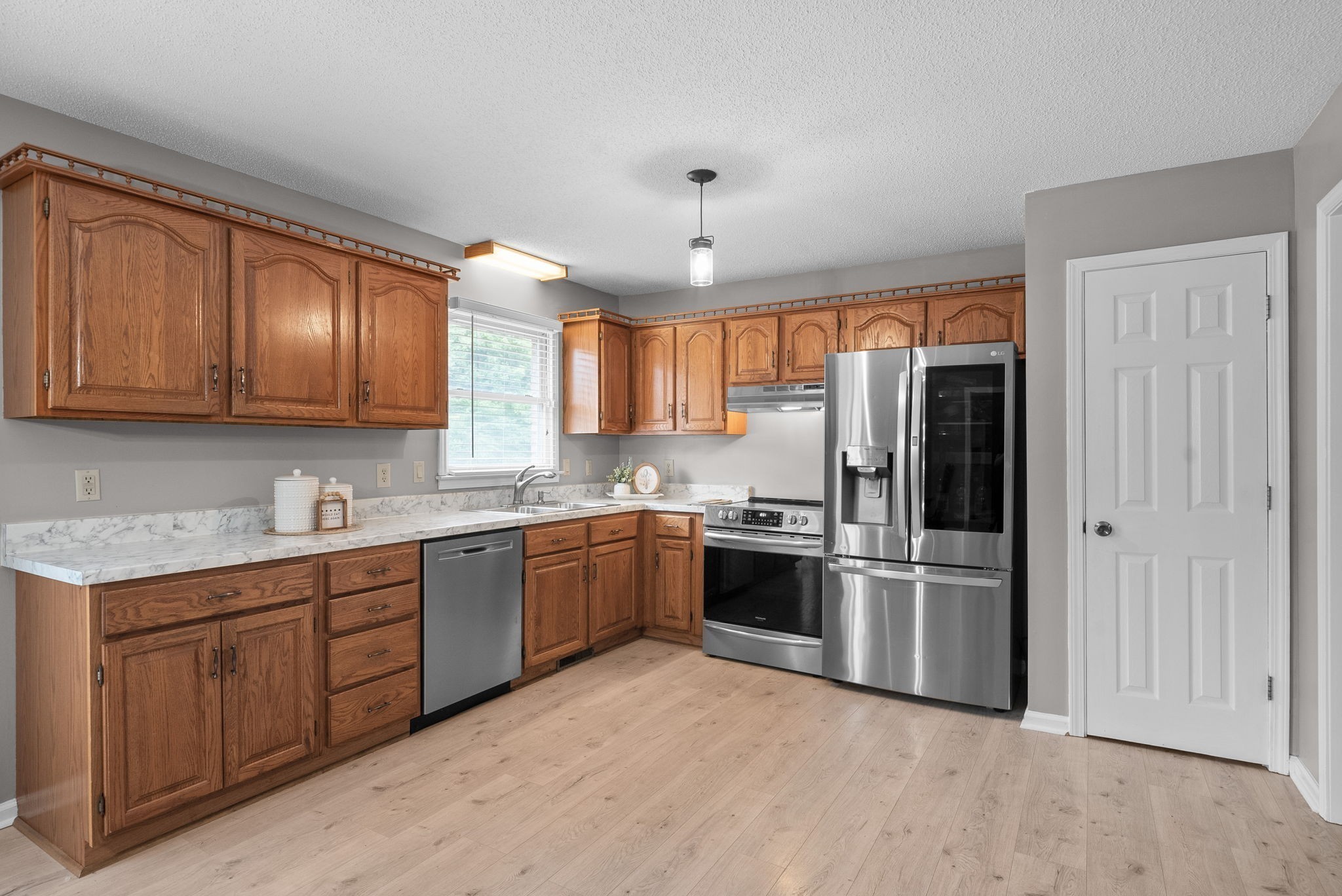 2430 Underwood Road Cunningham, TN 37052 - Photo 10 of 49 a kitchen with stainless steel appliances granite countertop a refrigerator a sink dishwasher a stove with wooden cabinets and floor