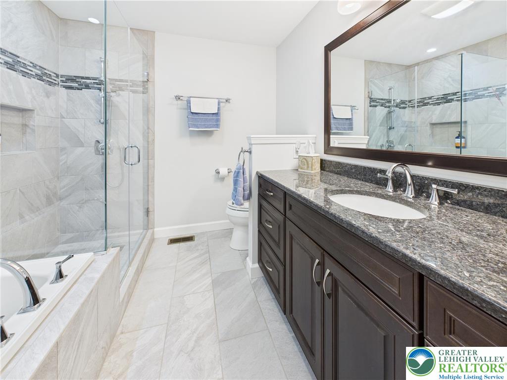 3006 Hope Ridge Drive Easton, PA 18045 - Photo 15 of 21 a spacious bathroom with a granite countertop sink a mirror a shower and a bathtub