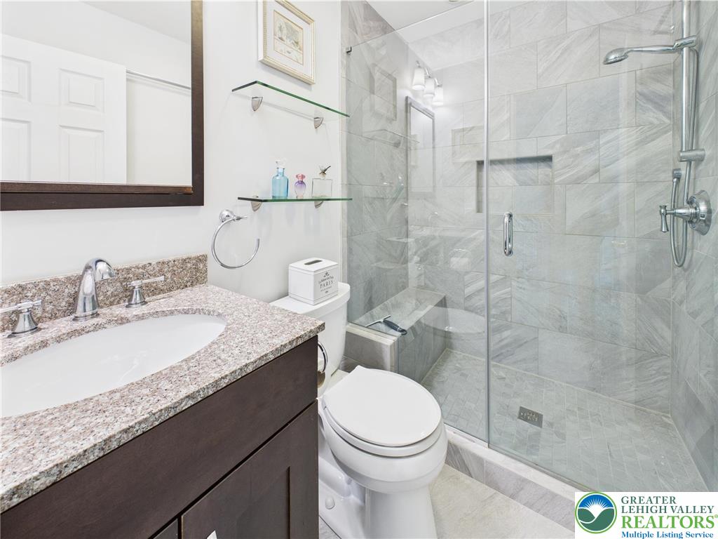 3006 Hope Ridge Drive Easton, PA 18045 - Photo 18 of 21 a bathroom with a granite countertop sink a toilet a mirror and shower