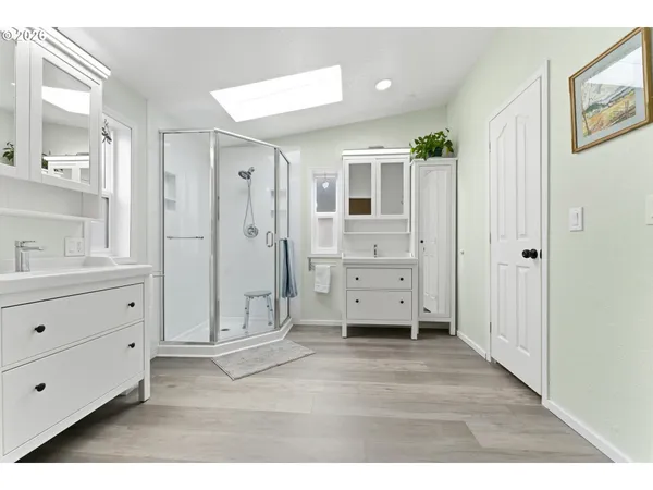a spacious bathroom with a glass door shower and a sink