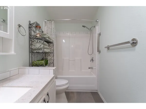 a bathroom with a granite countertop sink a toilet and shower