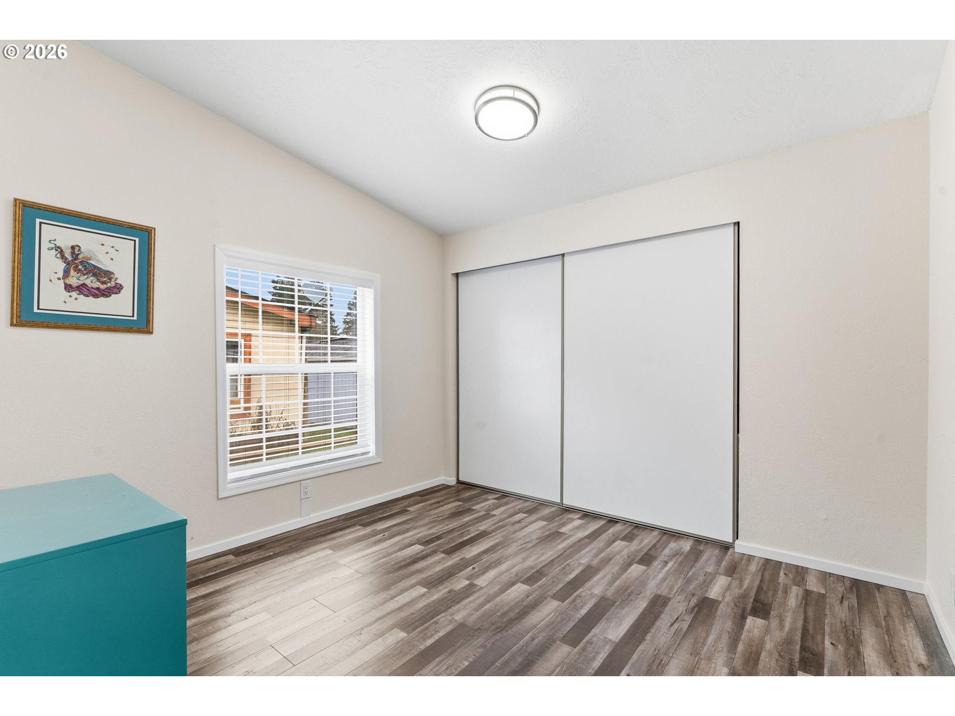 15768 Southeast Powell Boulevard, Unit 40 Portland, OR 97236 - Photo 23 of 33 a view of an empty room with wooden floor and a window