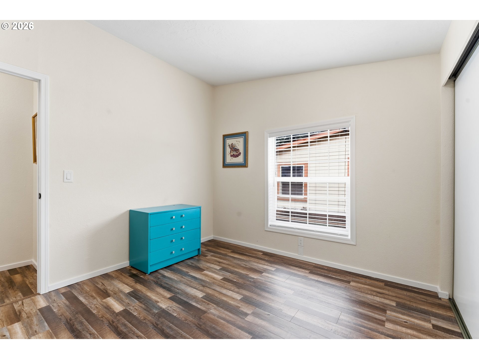 15768 Southeast Powell Boulevard, Unit 40 Portland, OR 97236 - Photo 24 of 33 a view of an empty room with wooden floor and a window