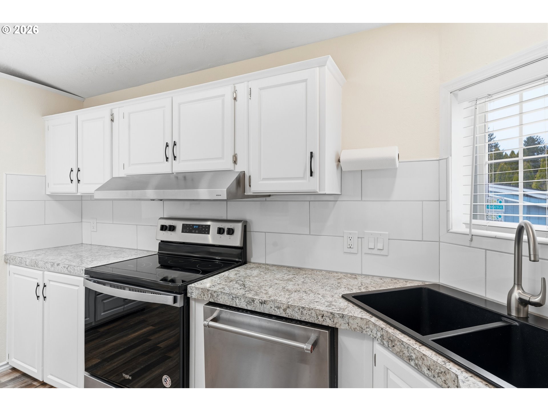 15768 Southeast Powell Boulevard, Unit 40 Portland, OR 97236 - Photo 7 of 33 a kitchen with granite countertop white cabinets and a stove