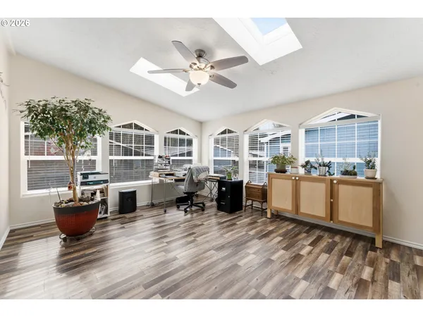 a living room with couches and kitchen view with wooden floor