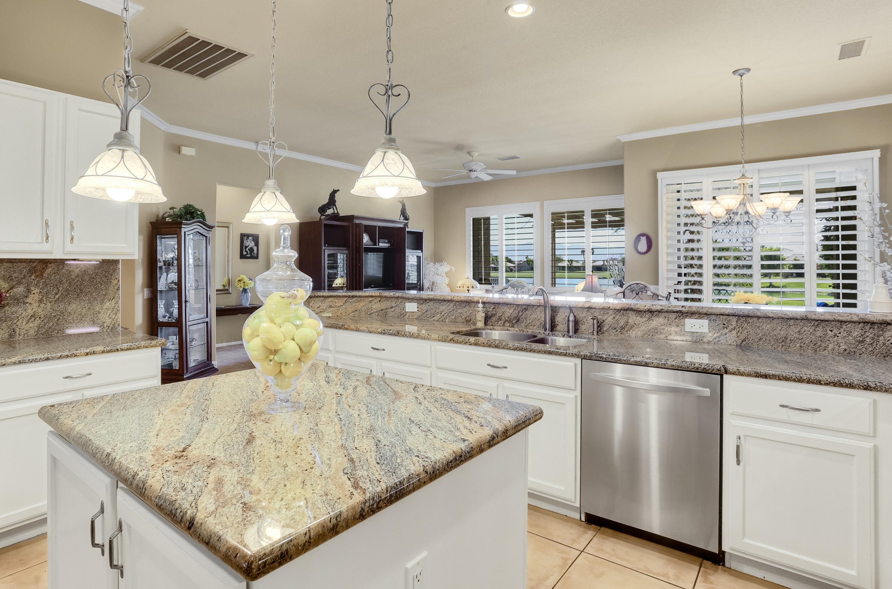 a kitchen with kitchen island granite countertop a table and a chandelier