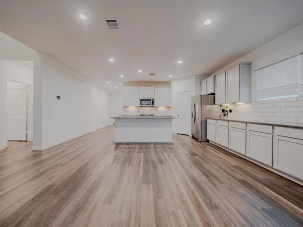 a kitchen with a sink window and cabinets
